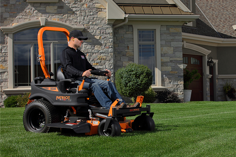 A man operating a Scag Patriot in a front yard.